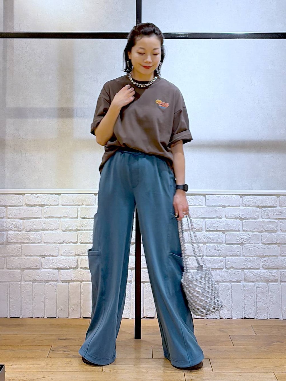 シルバー系のショルダーバッグ、ブラック系のサンダル、ブラウン系のTシャツ/カットソーを着用したレディースの春コーディネートの8枚目の写真