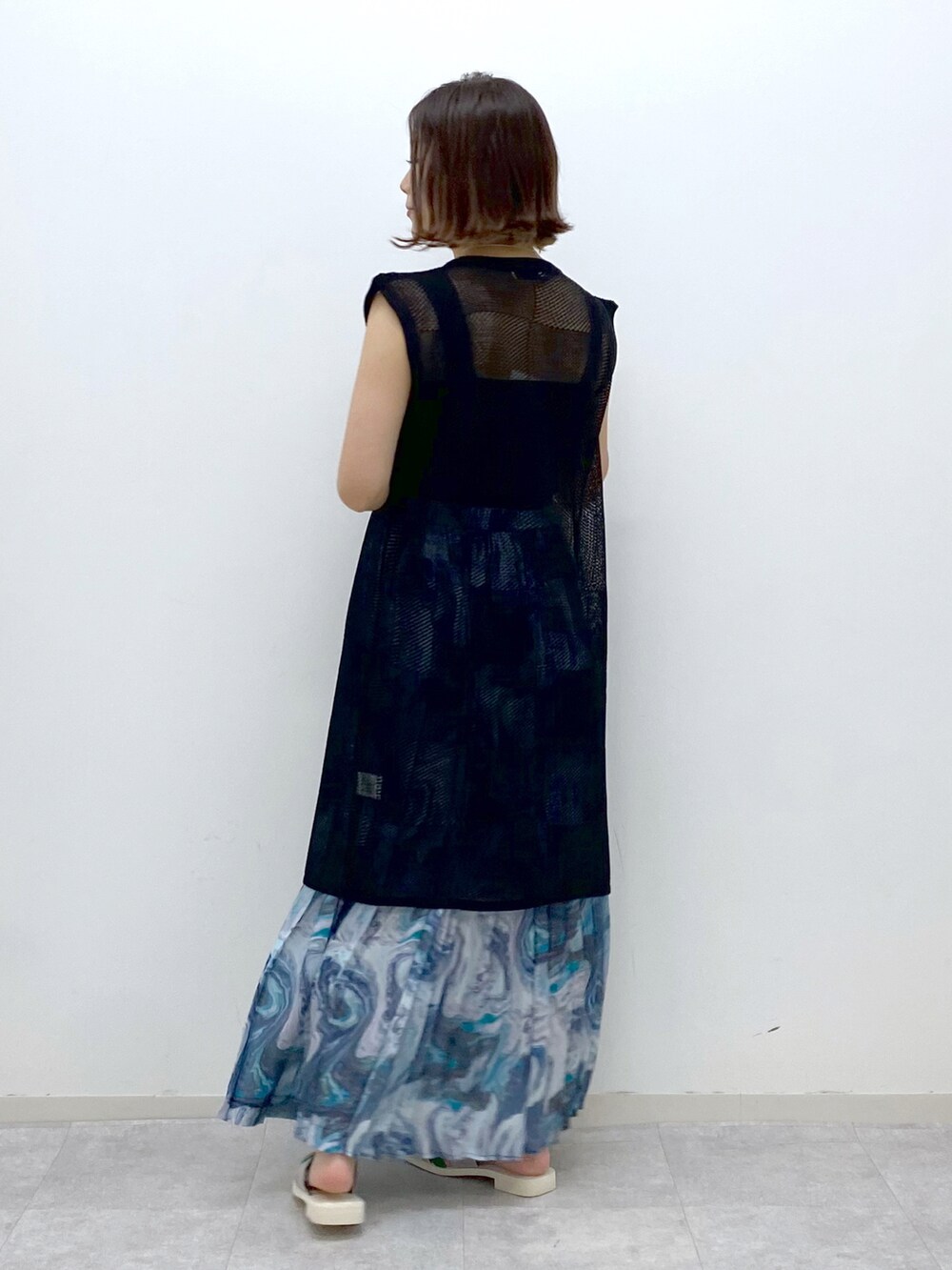 ブラック系のカーディガン/ボレロ、ブラック系のタンクトップ、ブルー系のスカートを着用したレディースの夏コーディネートの3枚目の写真