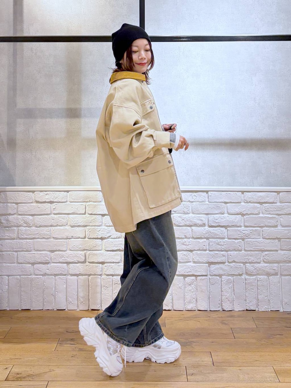 ホワイト系のスニーカー、ブラック系のボディバッグ/ウエストポーチ、ブルー系のデニムパンツを着用したレディースの冬コーディネートの5枚目の写真