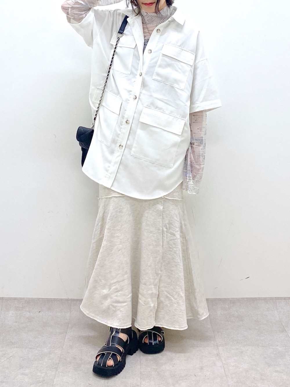 ホワイト系のトップス、ホワイト系のトップス、ブラック系のバッグを着用したレディースの春コーディネートの5枚目の写真