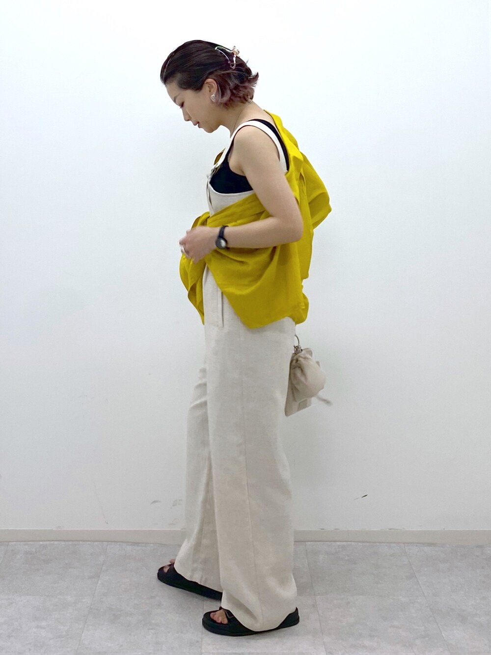 イエロー系のシャツ/ブラウス、ブラック系のサンダル、ブラック系のタンクトップを着用したレディースの夏コーディネートの3枚目の写真