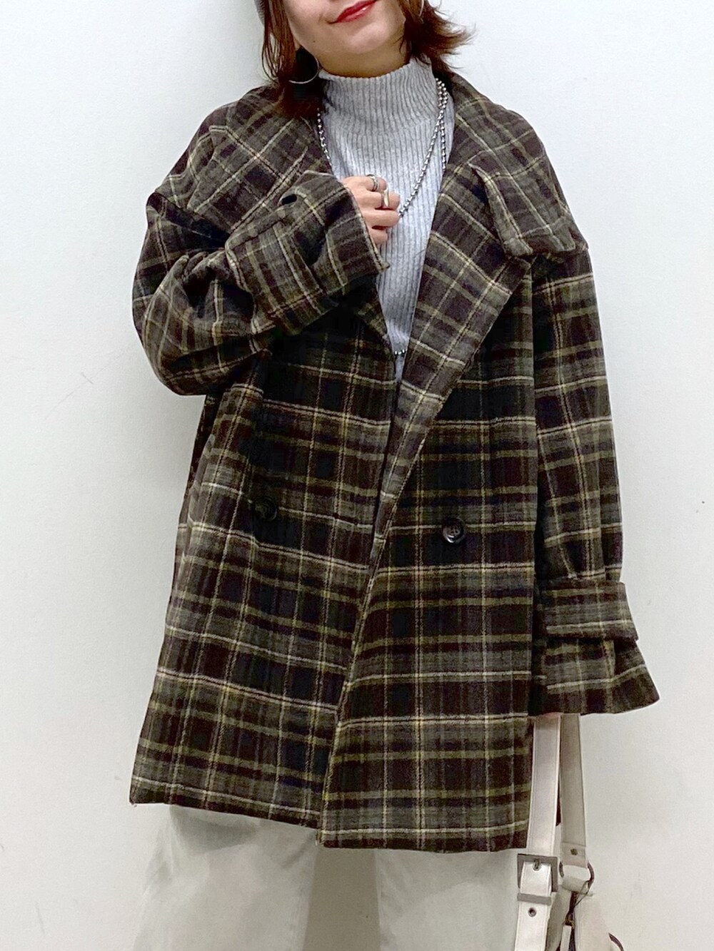 ブラウン系のテーラードジャケット、グレー系のデニムパンツ、ホワイト系のショルダーバッグを着用したレディースの冬コーディネートの2枚目の写真