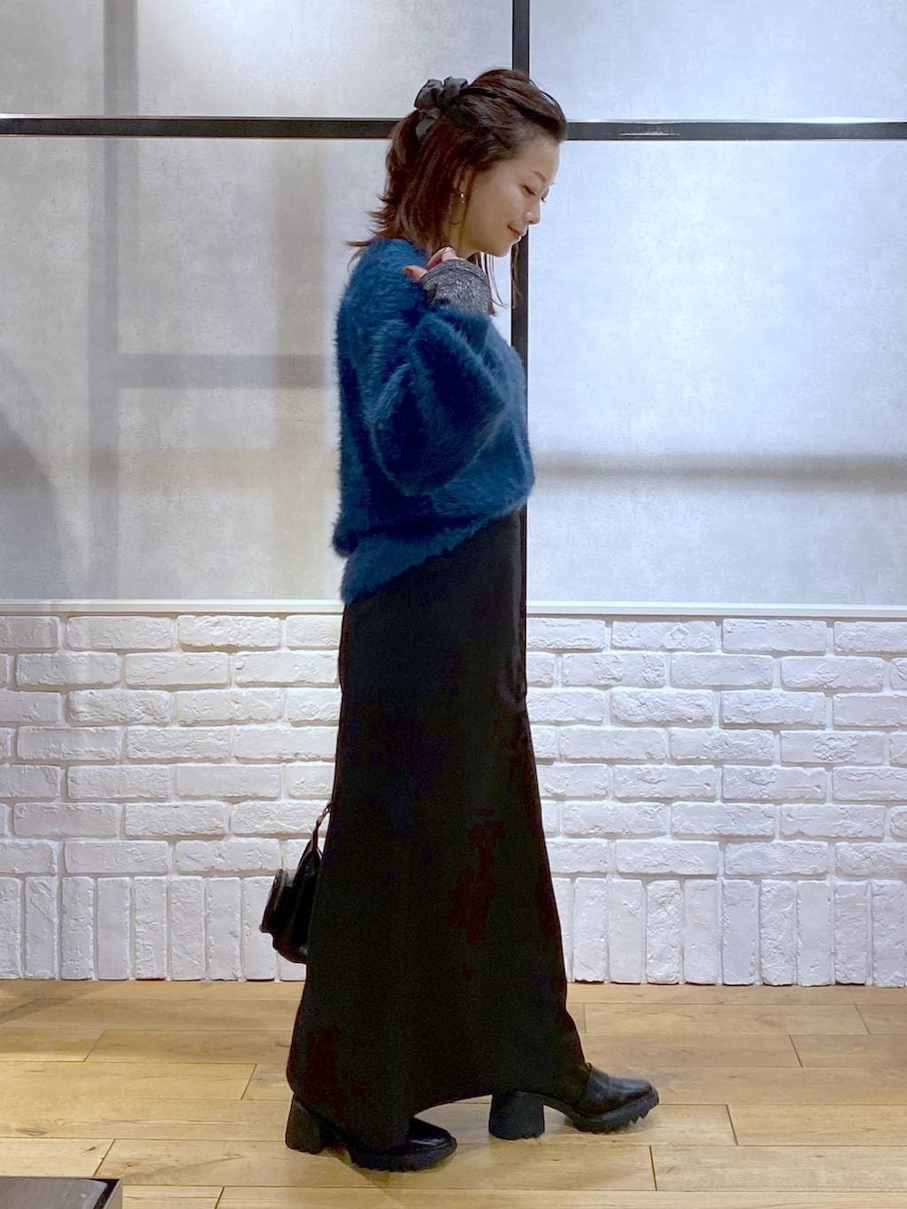 シルバー系のTシャツ/カットソー、ブラック系のブーツ、ブルー系のニット/セーターを着用したレディースの冬コーディネートの8枚目の写真