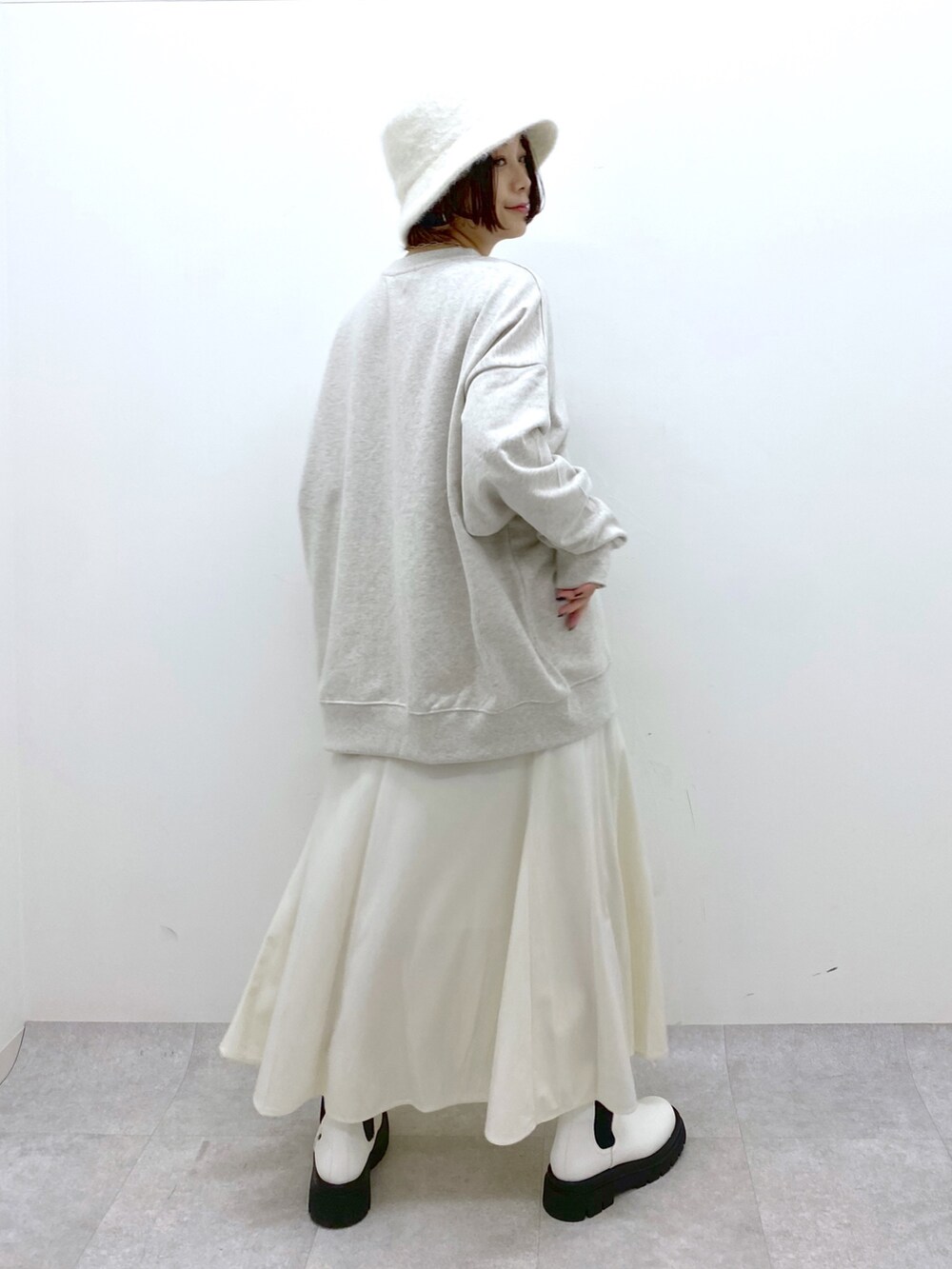 ベージュ系のトップス、ホワイト系のスカート、ホワイト系のシューズを着用したレディースの秋コーディネートの3枚目の写真