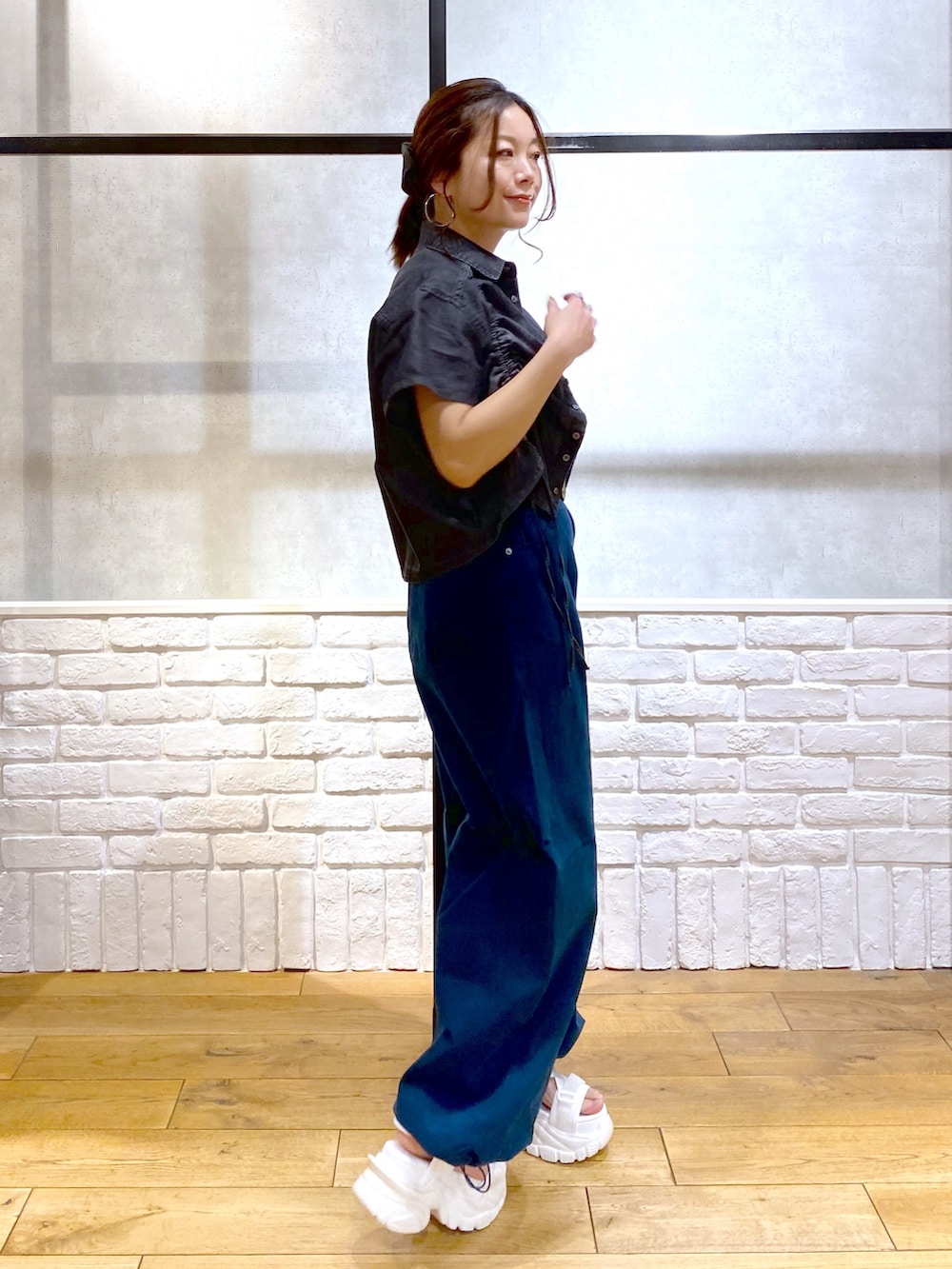 ホワイト系のタンクトップ、ブルー系のチノパンツ、ホワイト系のサンダルを着用したレディースの春コーディネートの5枚目の写真