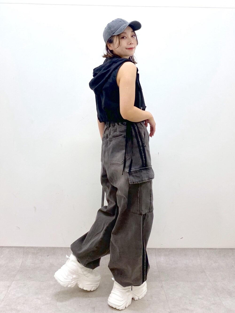 ブラウン系のデニムパンツ、ブラック系のショルダーバッグ、ホワイト系のスニーカーを着用したレディースの夏コーディネートの7枚目の写真