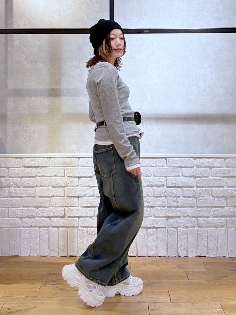 ホワイト系のスニーカー、ブラック系のボディバッグ/ウエストポーチ、ブルー系のデニムパンツを着用したレディースの春コーディネートの7枚目の写真