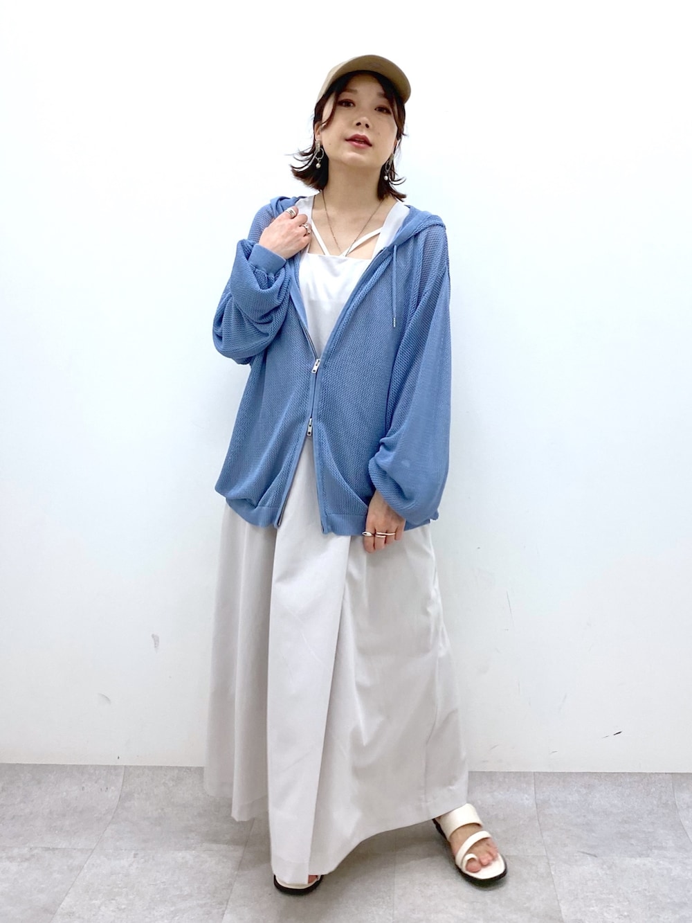 ベージュ系のジャンパースカート、ブルー系のニット/セーター、ブラック系のキャミソールを着用したレディースの夏コーディネートの6枚目の写真