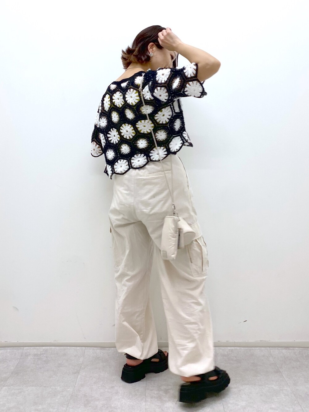 ホワイト系のカーゴパンツ、イエロー系のタンクトップ、ブラック系のトップスを着用したレディースの夏コーディネートの3枚目の写真