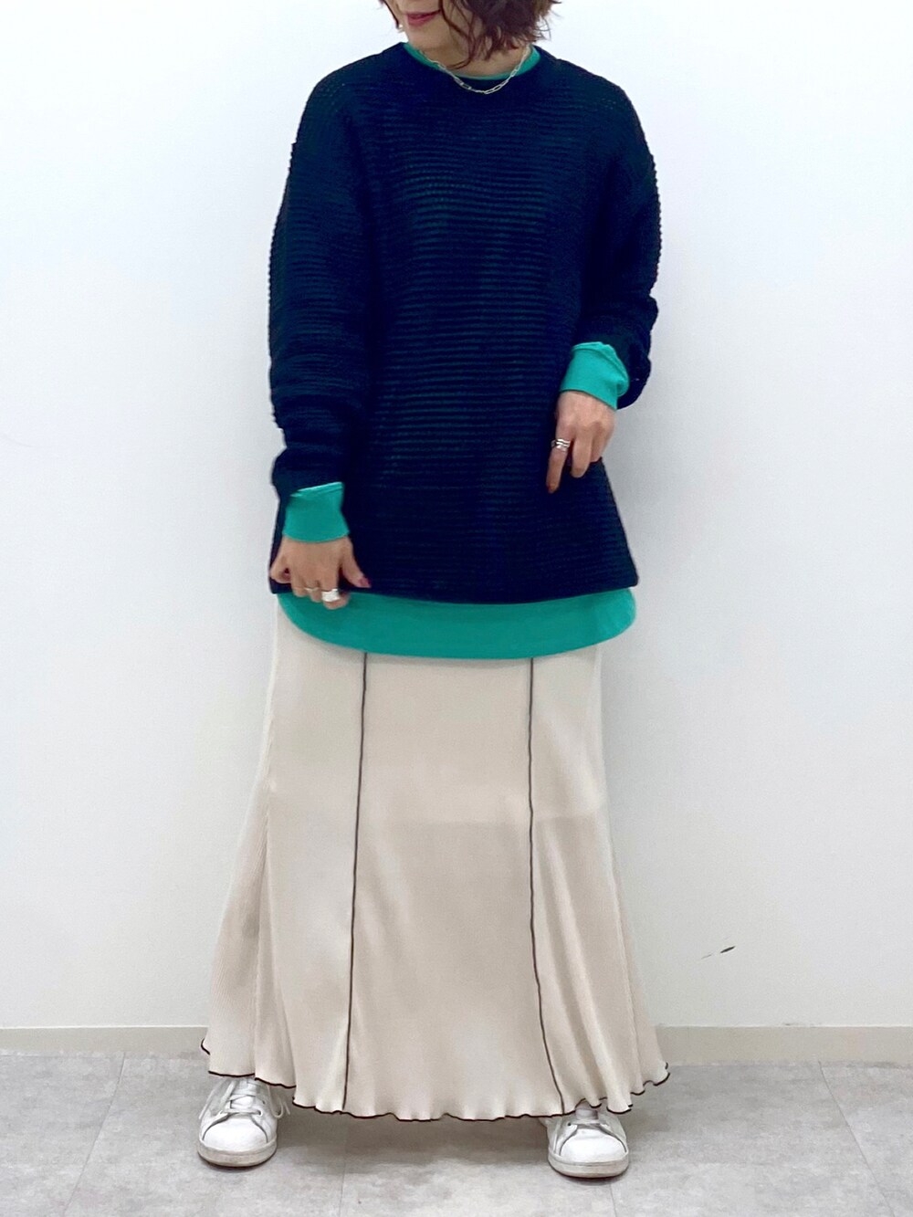 ブラック系のニット/セーター、グリーン系のTシャツ/カットソー、ホワイト系のスカートを着用したレディースの春コーディネートの5枚目の写真
