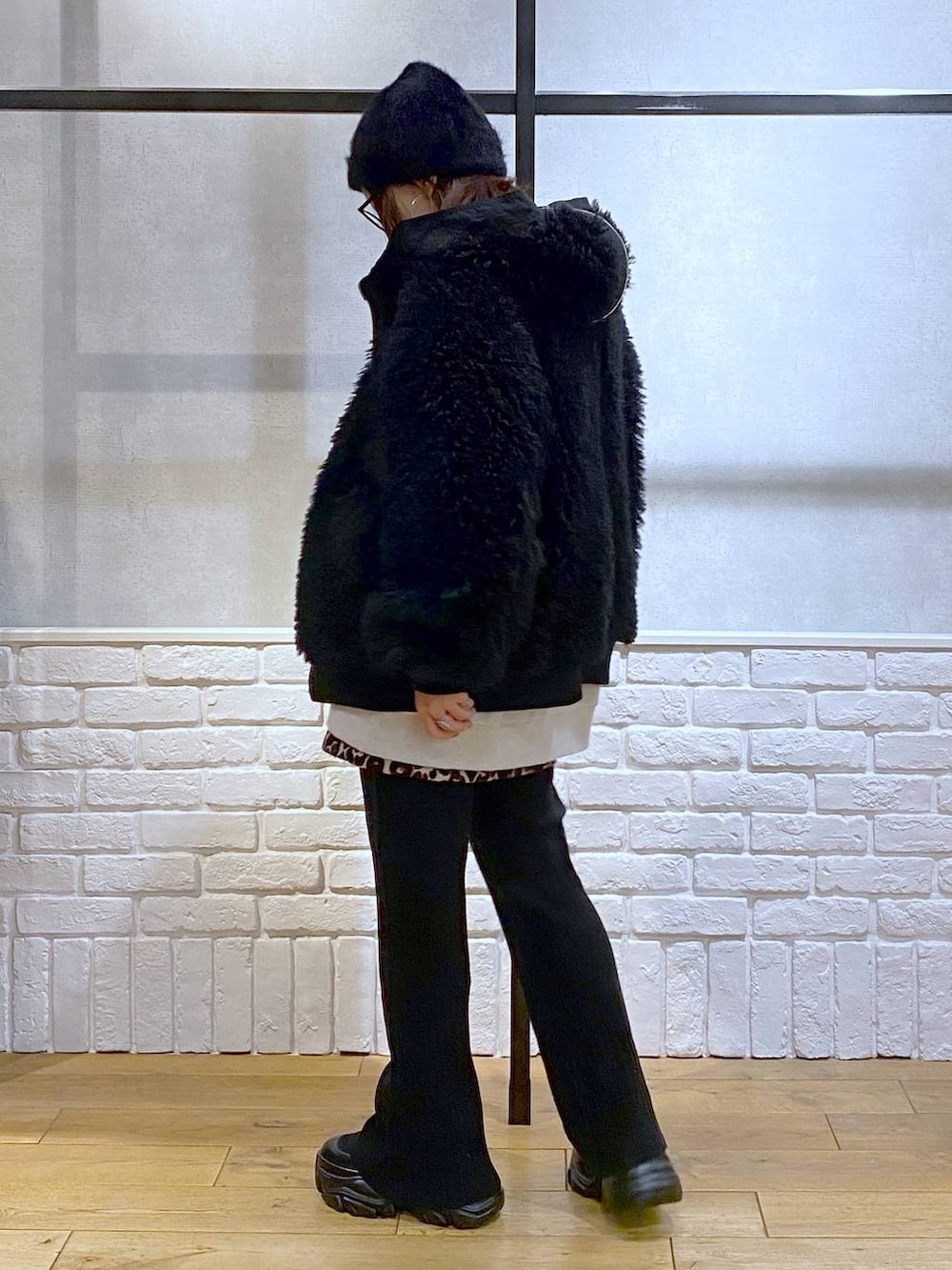 ブラック系のブーツ、ブラック系のブルゾン、ブラウン系のスカートを着用したレディースの冬コーディネートの8枚目の写真