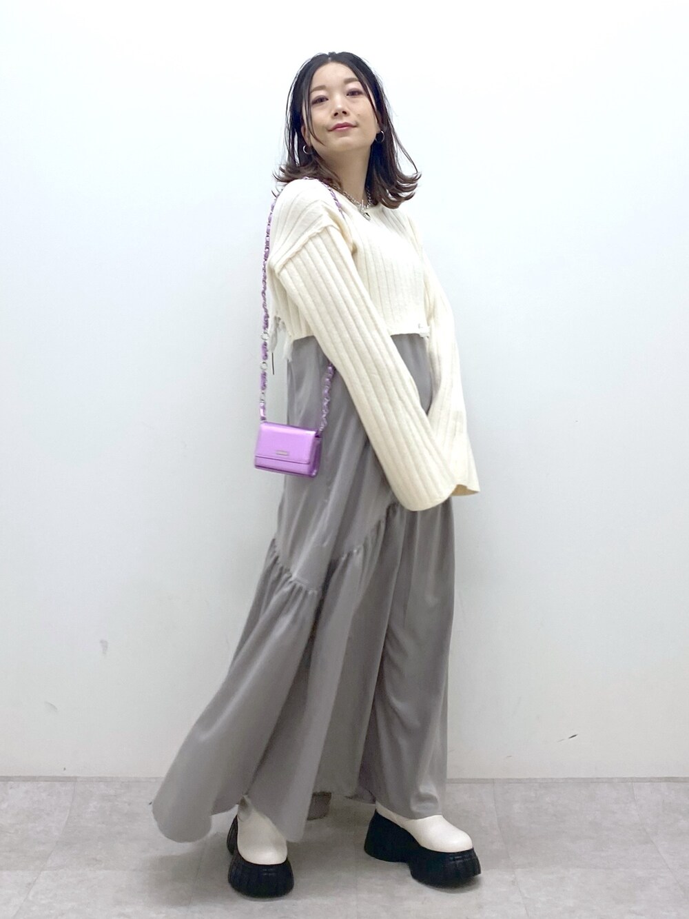 ホワイト系のワンピース、ピンク系のショルダーバッグ、ホワイト系のブーツを着用したレディースの冬コーディネートの8枚目の写真