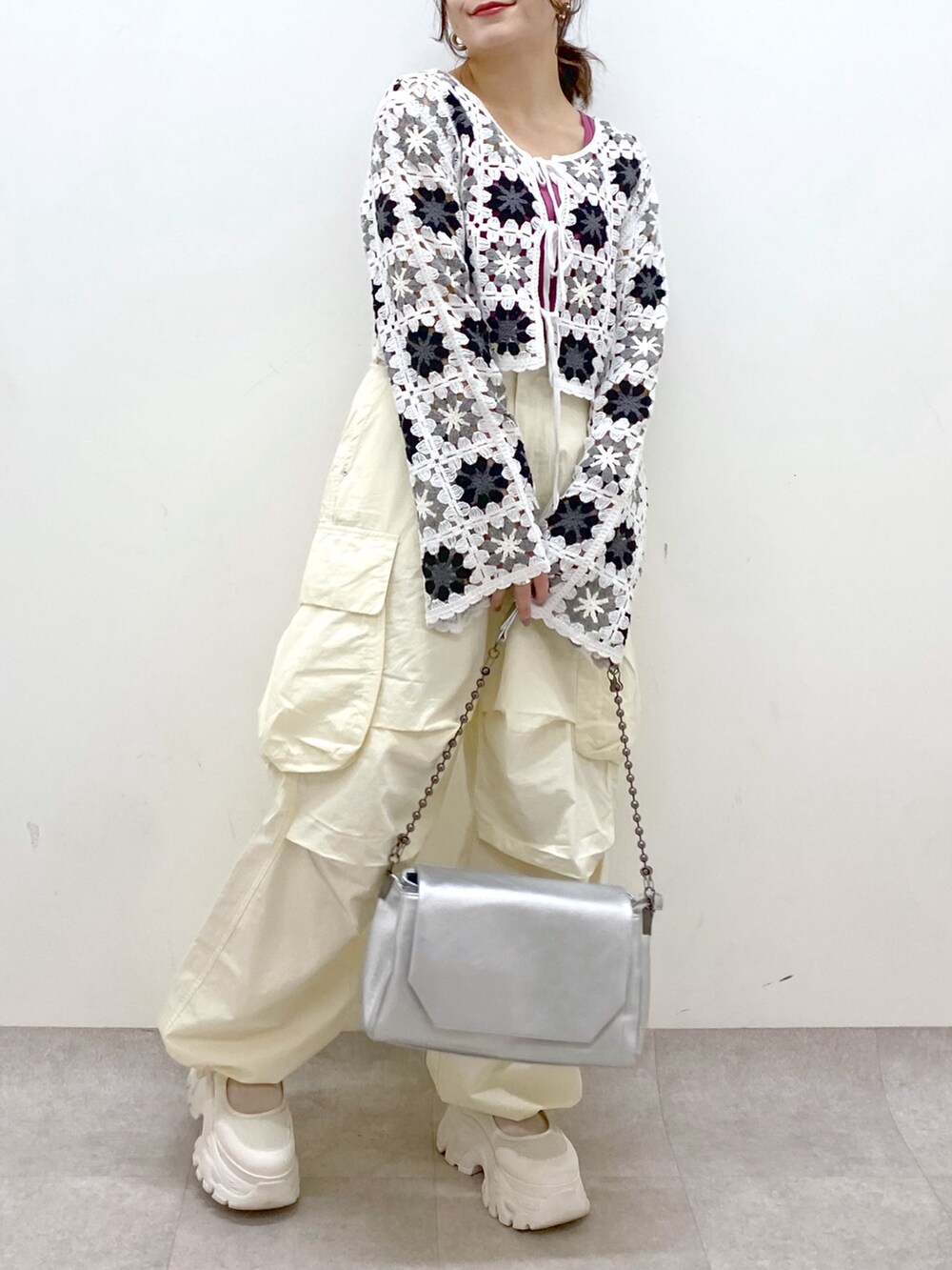 ホワイト系のカーディガン/ボレロ、ピンク系のタンクトップ、ホワイト系のカーゴパンツを着用したレディースの春コーディネートの3枚目の写真