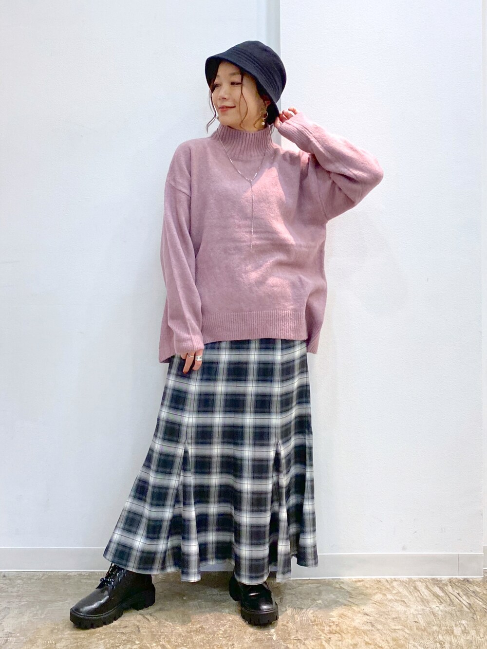 ピンク系のニット/セーター、ブラック系のスカート、ブラック系のブーツを着用したレディースの冬コーディネートの5枚目の写真