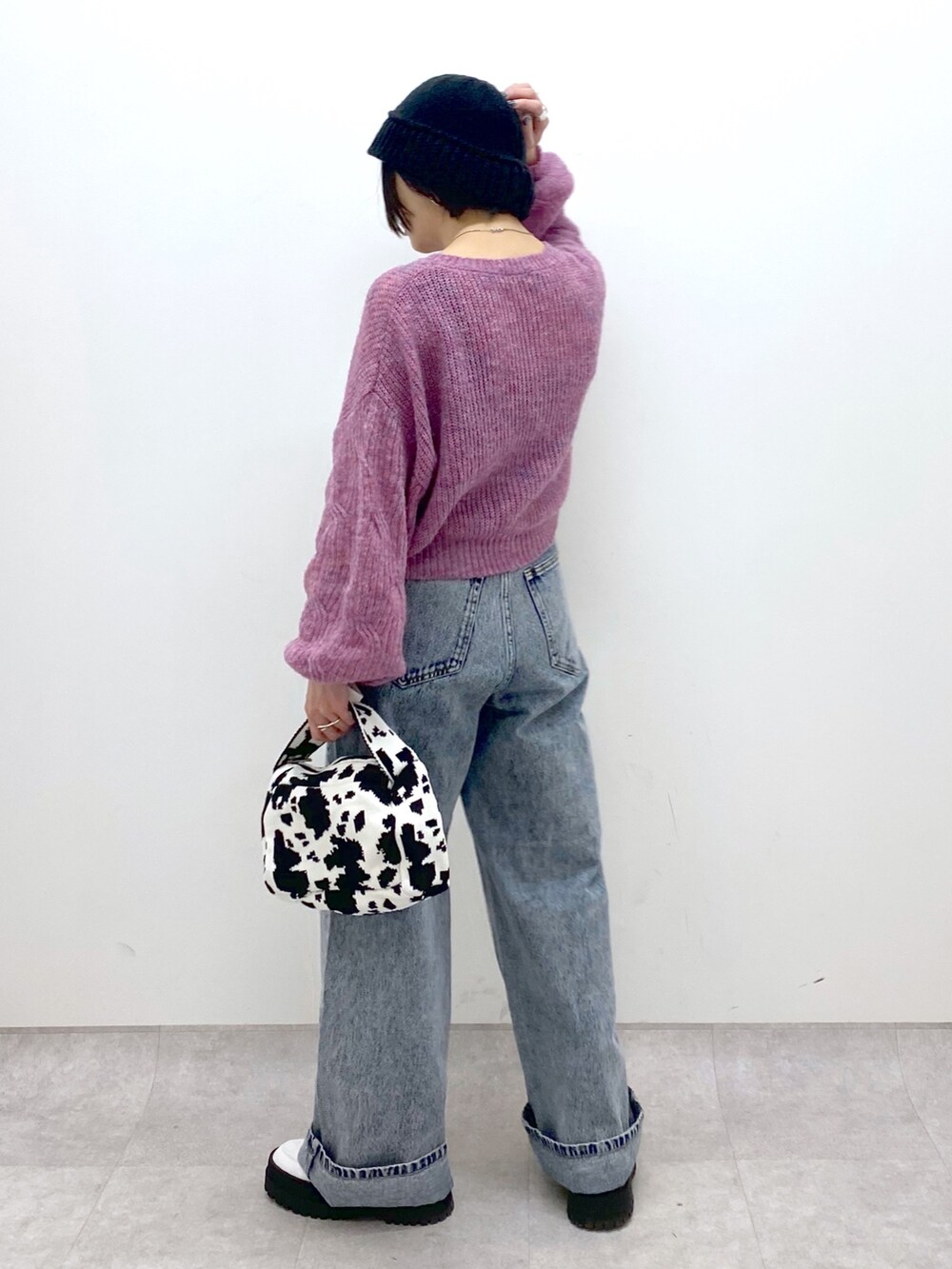 ブラック系のバッグ、ブルー系のデニムパンツ、ホワイト系のシューズを着用したレディースの冬コーディネートの3枚目の写真