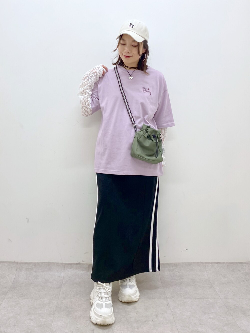 ブラック系のスカート、ホワイト系のスニーカー、ホワイト系のTシャツ/カットソーを着用したレディースの夏コーディネートの9枚目の写真