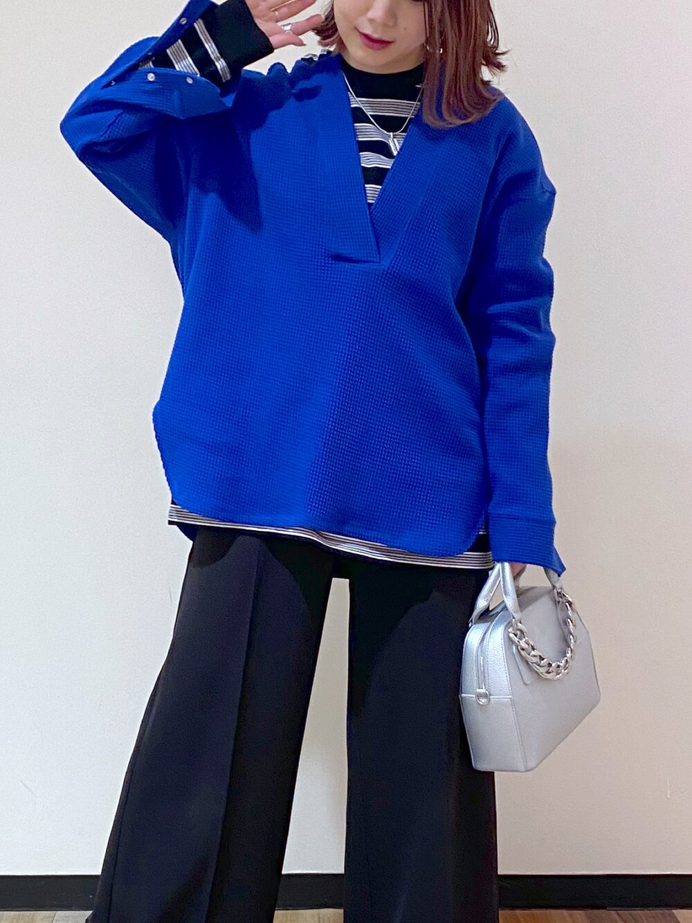 シルバー系のショルダーバッグ、ブラック系のブーツ、ブルー系のTシャツ/カットソーを着用したレディースの冬コーディネートの4枚目の写真