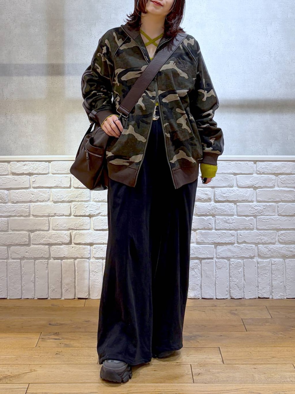 グレー系のスニーカー、ブラウン系のボストンバッグ、イエロー系のニット/セーターを着用したレディースの冬コーディネートの3枚目の写真