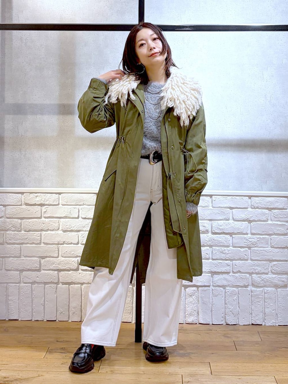 ベージュ系のボストンバッグ、グリーン系のモッズコート、ブラック系のローファーを着用したレディースの冬コーディネートの9枚目の写真