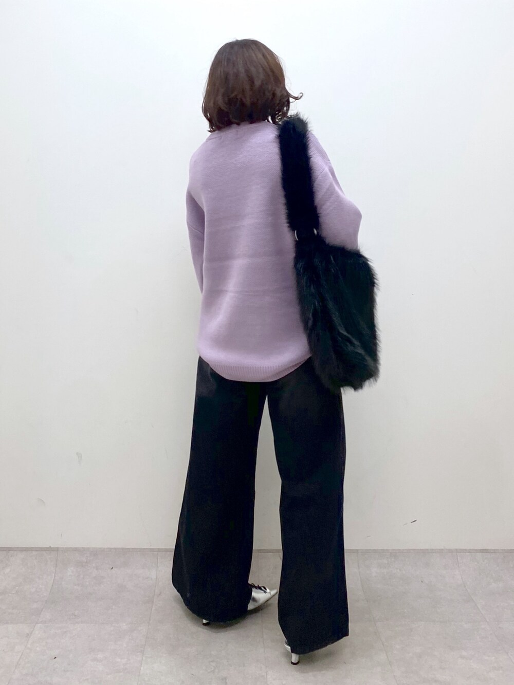 パープル系のニット/セーター、ブラック系のデニムパンツ、シルバー系のパンプスを着用したレディースの秋コーディネートの6枚目の写真