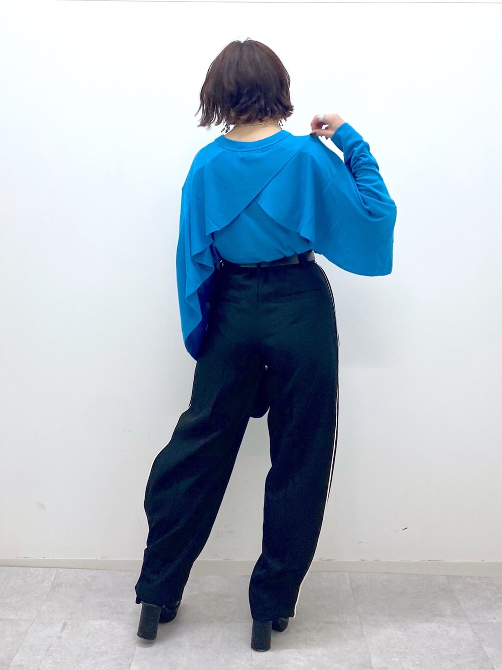 ブラック系のブーツ、ブラック系のパンツ、ブラック系のバッグを着用したレディースの秋コーディネートの3枚目の写真