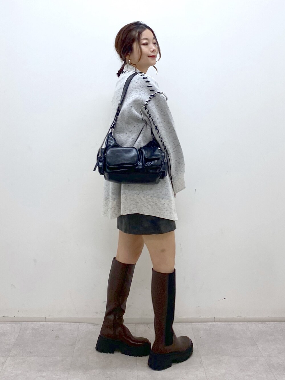 ホワイト系のニット/セーター、シルバー系のTシャツ/カットソー、ブラック系のスカートを着用したレディースの秋コーディネートの5枚目の写真