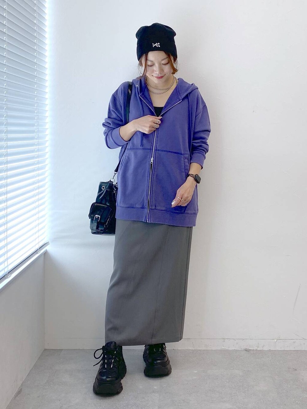 ブラック系のスニーカー、グレー系のスカート、ブラック系のショルダーバッグを着用したレディースの秋コーディネートの8枚目の写真