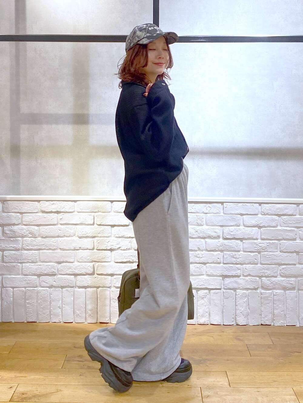 ブラック系のスニーカー、グリーン系のボストンバッグ、グレー系のスウェットパンツを着用したレディースの秋コーディネートの5枚目の写真