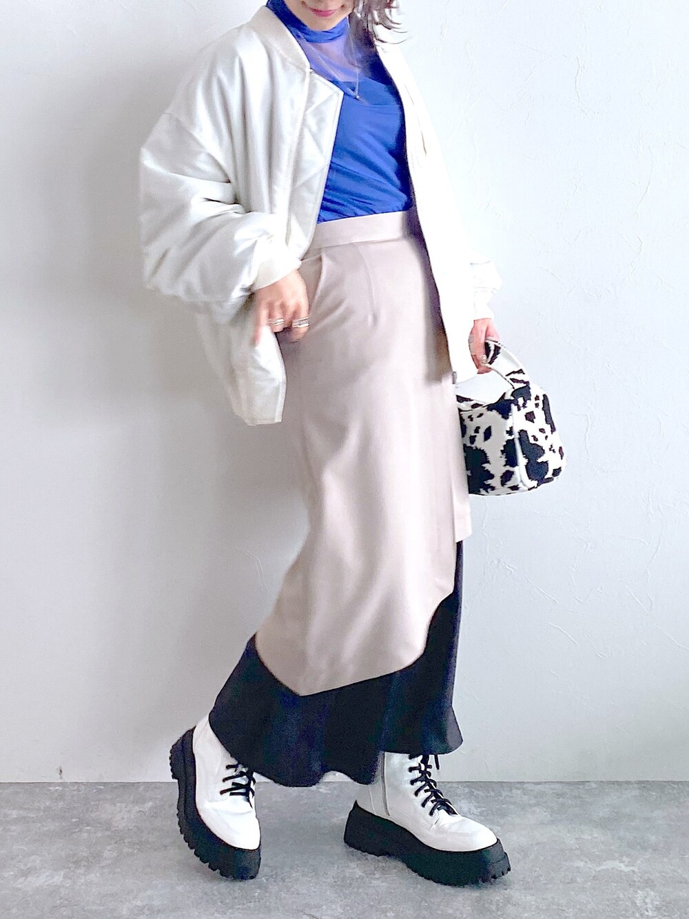 ホワイト系のMA-1、ベージュ系のスカート、ホワイト系のブーツを着用したレディースの夏コーディネートの4枚目の写真