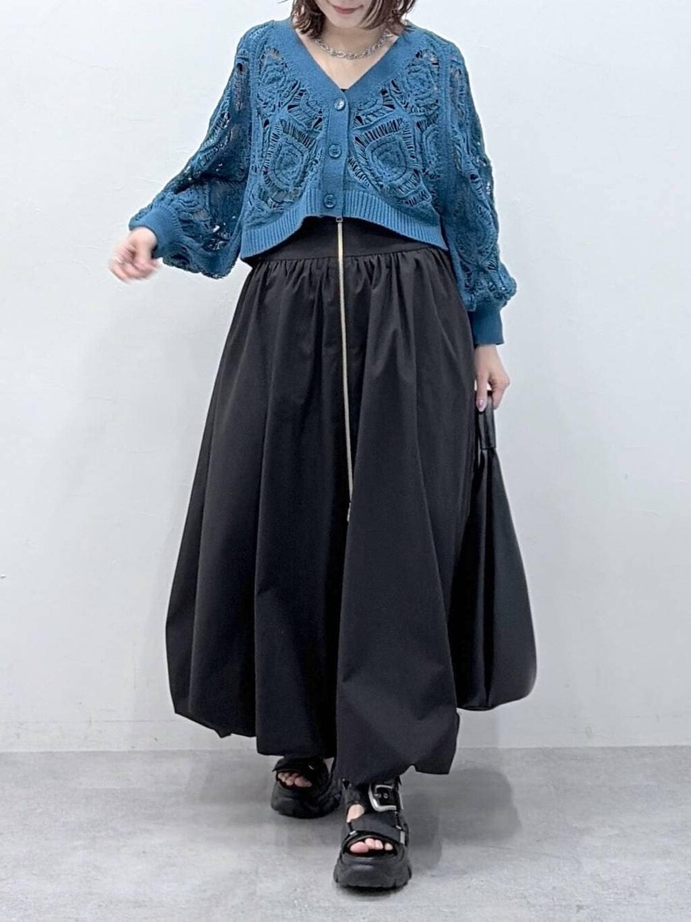 ブルー系のカーディガン/ボレロ、ブラック系のスカートを着用したレディースの春コーディネートの3枚目の写真