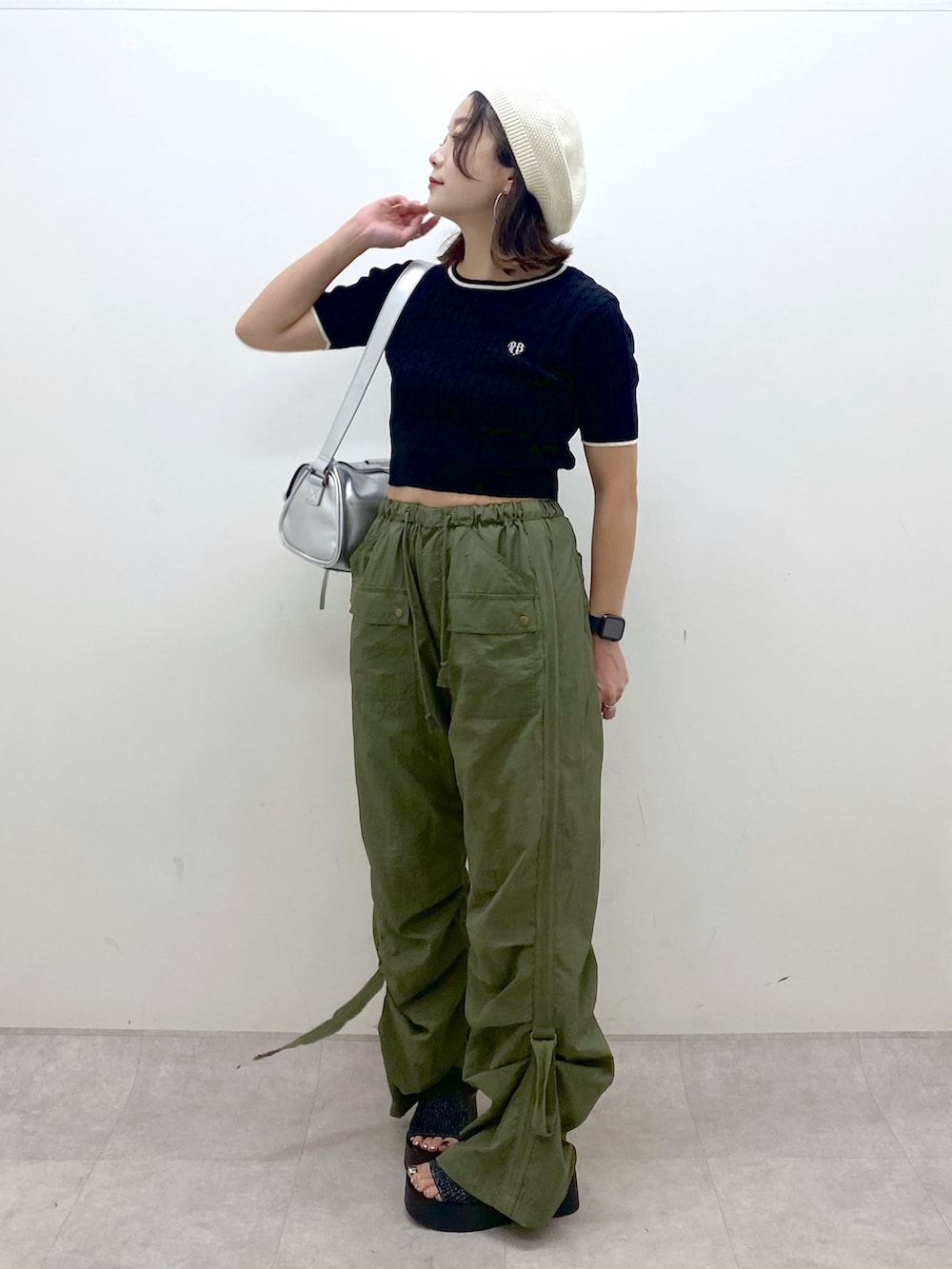 グリーン系のカーゴパンツ、ブラック系のサンダル、シルバー系のショルダーバッグを着用したレディースの夏コーディネートの4枚目の写真