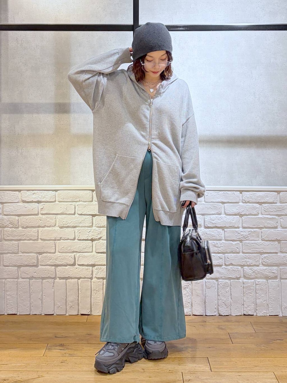 グレー系のスニーカー、グレー系のパーカー、ブラック系のショルダーバッグを着用したレディースの春コーディネートの9枚目の写真