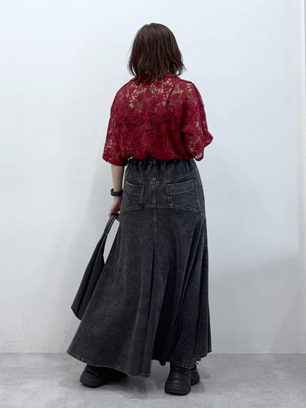 ブラック系のスニーカー、レッド系のシャツ/ブラウス、ブラック系のデニムスカートを着用したレディースの春コーディネートの5枚目の写真