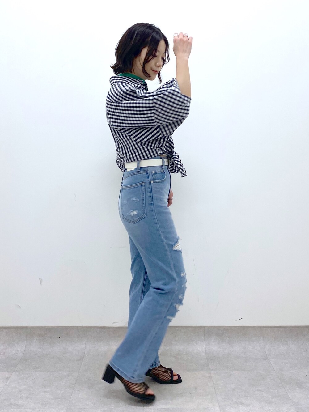 ブルー系のパンツ、ブラック系のシューズ、グリーン系のトップスを着用したレディースの春コーディネートの3枚目の写真