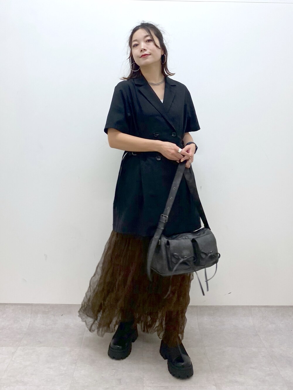 ブラック系のテーラードジャケット、ブラウン系のスカート、ブラック系のショルダーバッグを着用したレディースの夏コーディネートの8枚目の写真