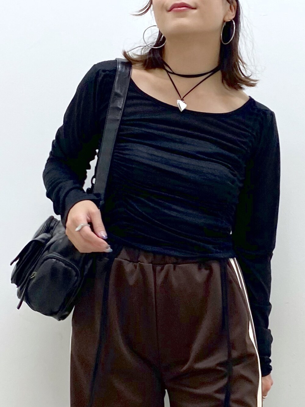 ブラウン系のその他パンツ、ブラック系のTシャツ/カットソー、ブラック系のショルダーバッグを着用したレディースの夏コーディネートの2枚目の写真