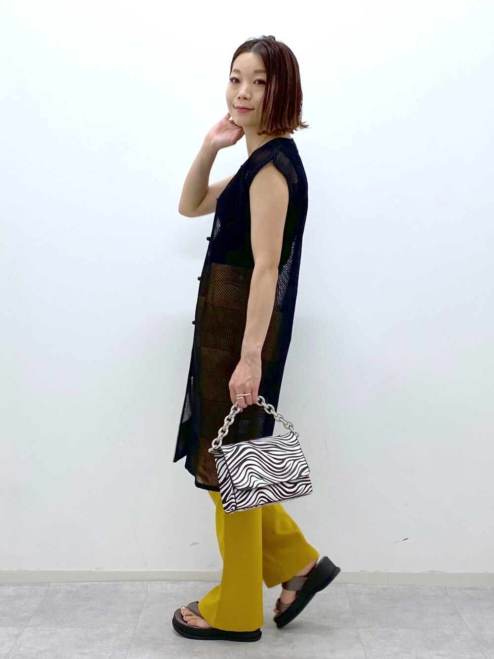 ブラック系のカーディガン/ボレロ、ブラック系のタンクトップ、その他のショルダーバッグを着用したレディースの春コーディネートの3枚目の写真