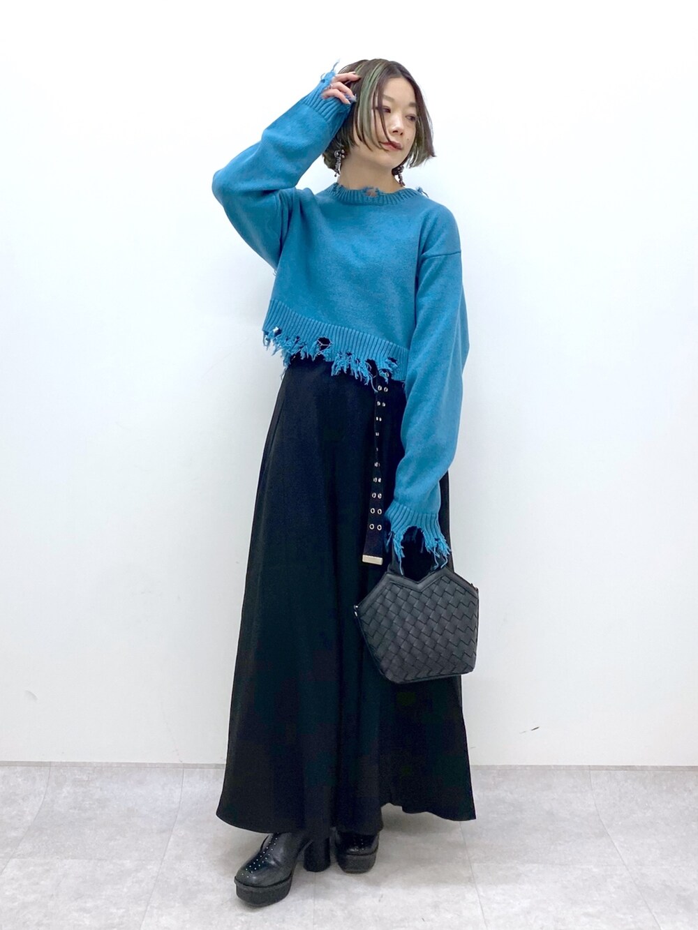 ブラック系のショルダーバッグ、ブラック系のスラックス、ブラック系のブーツを着用したレディースの冬コーディネートの5枚目の写真