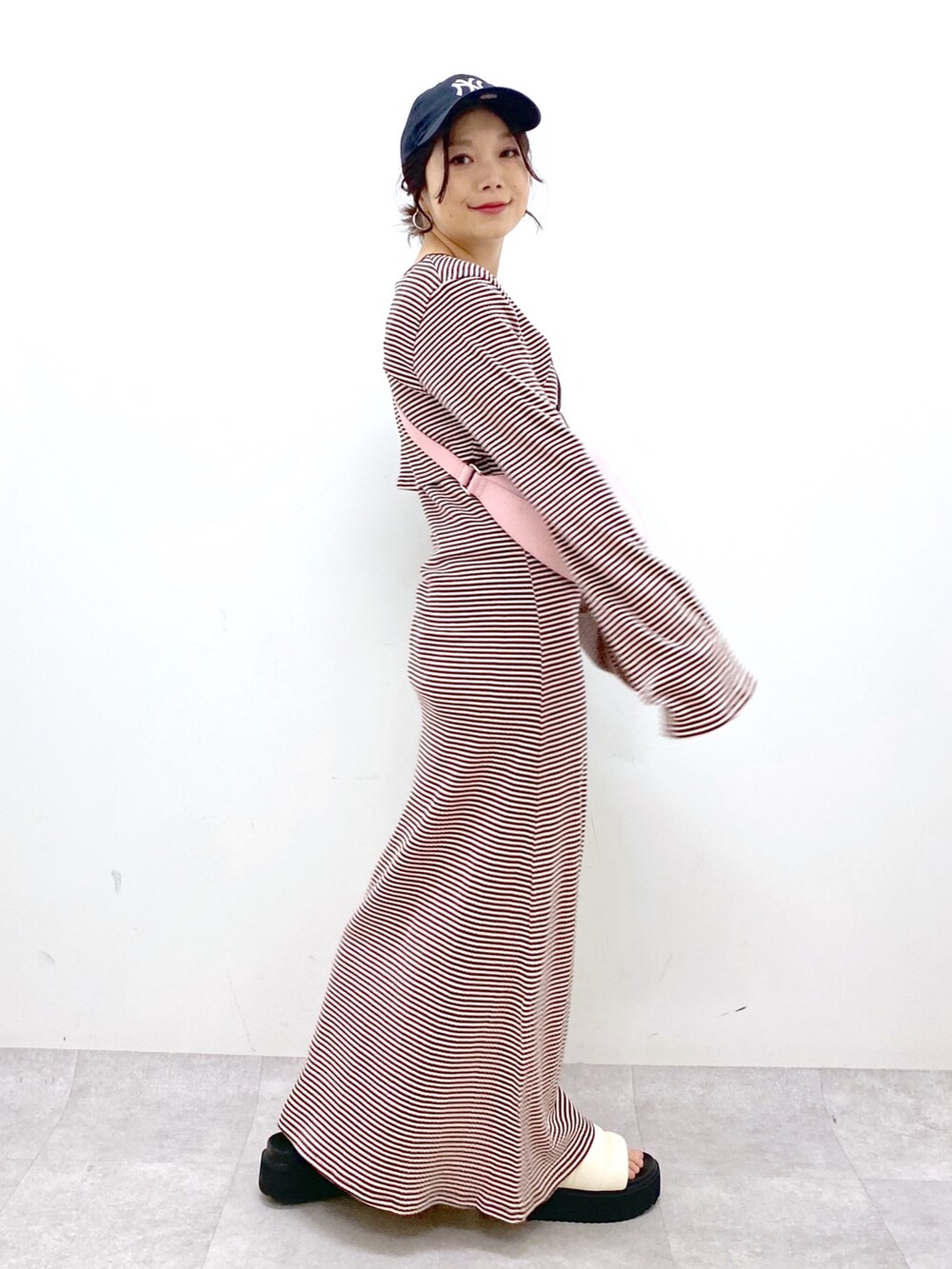 ブラウン系のワンピース、ピンク系のショルダーバッグ、ホワイト系のサンダルを着用したレディースの春コーディネートの4枚目の写真