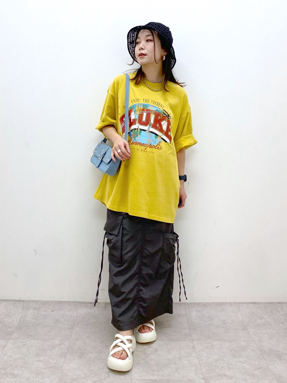 グレー系のスカート、ホワイト系のサンダル、ブルー系のハンドバッグを着用したレディースの春コーディネートの4枚目の写真