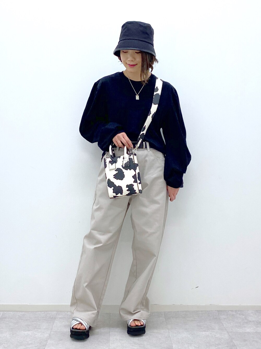 ブラック系のTシャツ/カットソー、ホワイト系のショルダーバッグ、グレー系のその他パンツを着用したレディースの春コーディネートの5枚目の写真