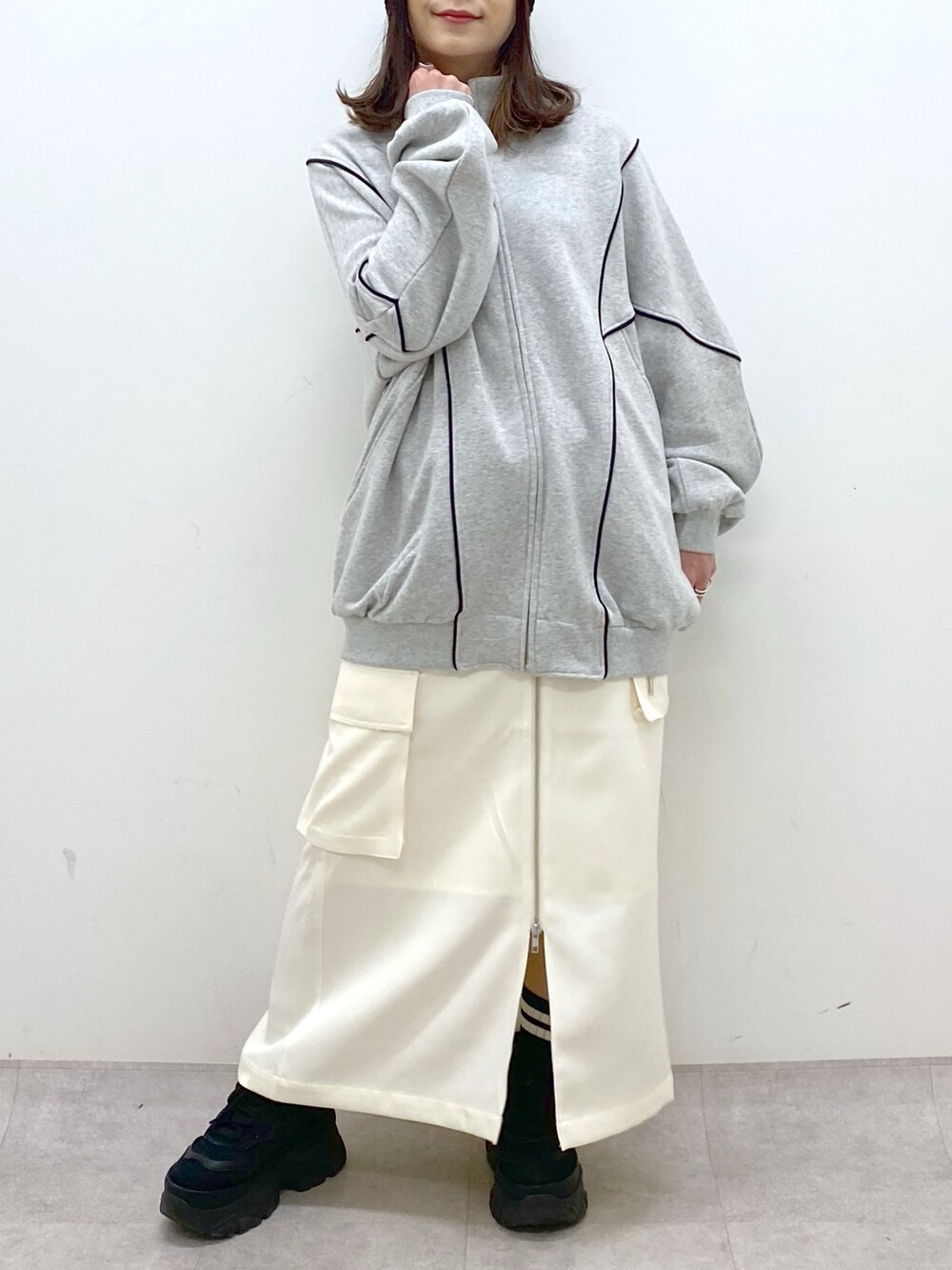 ホワイト系のスカート、ブラック系のスニーカー、グレー系のスウェットを着用したレディースの冬コーディネートの6枚目の写真