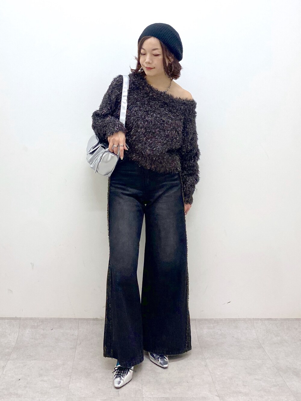 ブラック系のデニムパンツ、シルバー系のパンプス、シルバー系のショルダーバッグを着用したレディースの秋コーディネートの4枚目の写真