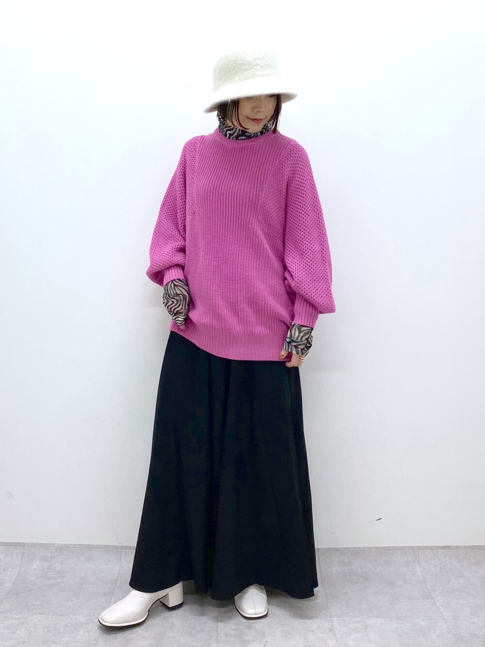 ピンク系のニット/セーター、ブラック系のスラックス、ブラック系のトップスを着用したレディースの冬コーディネートの5枚目の写真