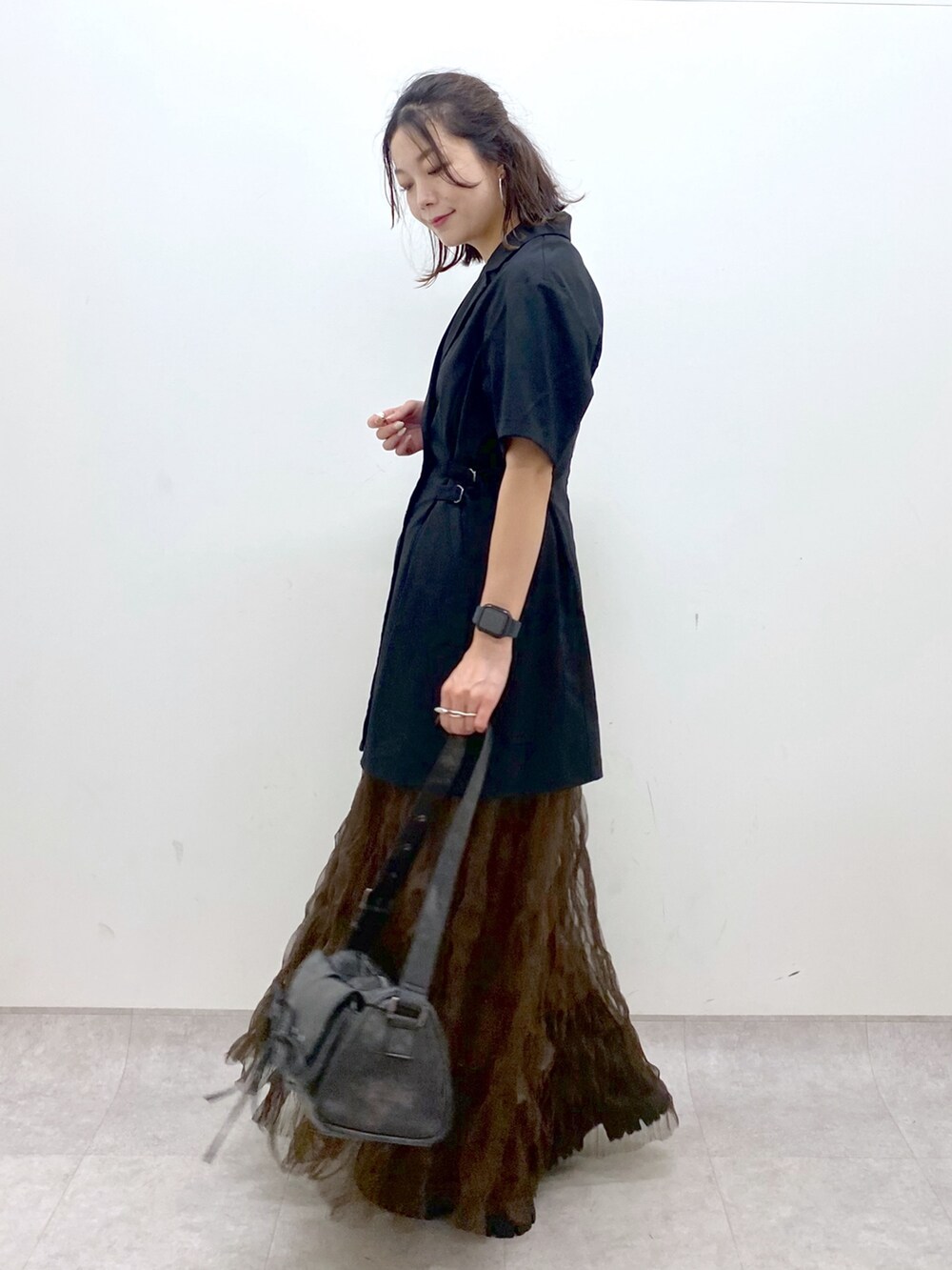 ブラック系のテーラードジャケット、ブラウン系のスカート、ブラック系のショルダーバッグを着用したレディースの夏コーディネートの5枚目の写真