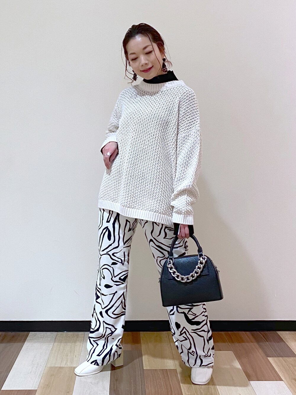 ホワイト系のその他パンツ、ホワイト系のサンダル、ブラック系のショルダーバッグを着用したレディースの冬コーディネートの2枚目の写真