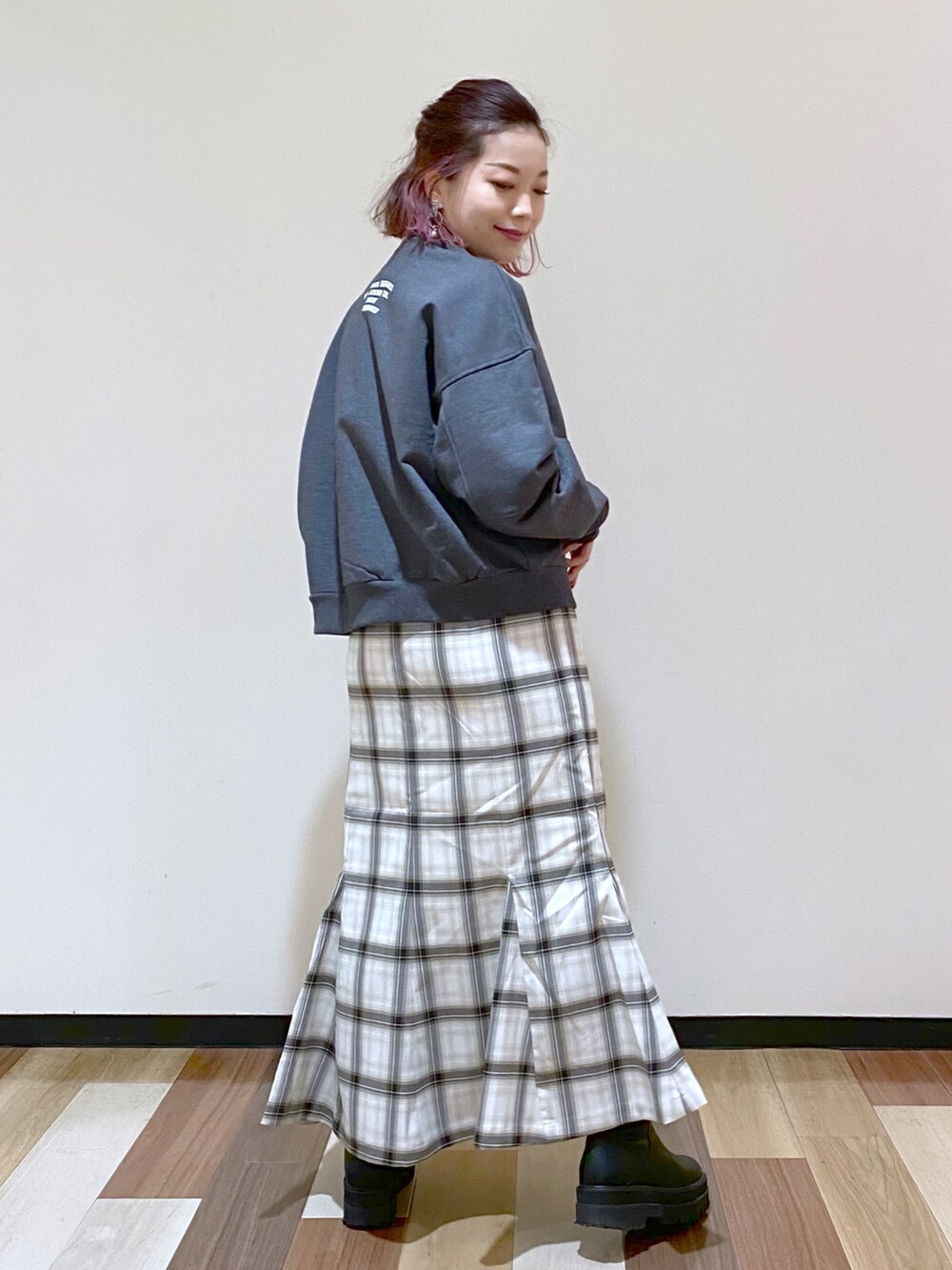 グレー系のスウェット、ホワイト系のスカート、ブラック系のブーツを着用したレディースの冬コーディネートの3枚目の写真