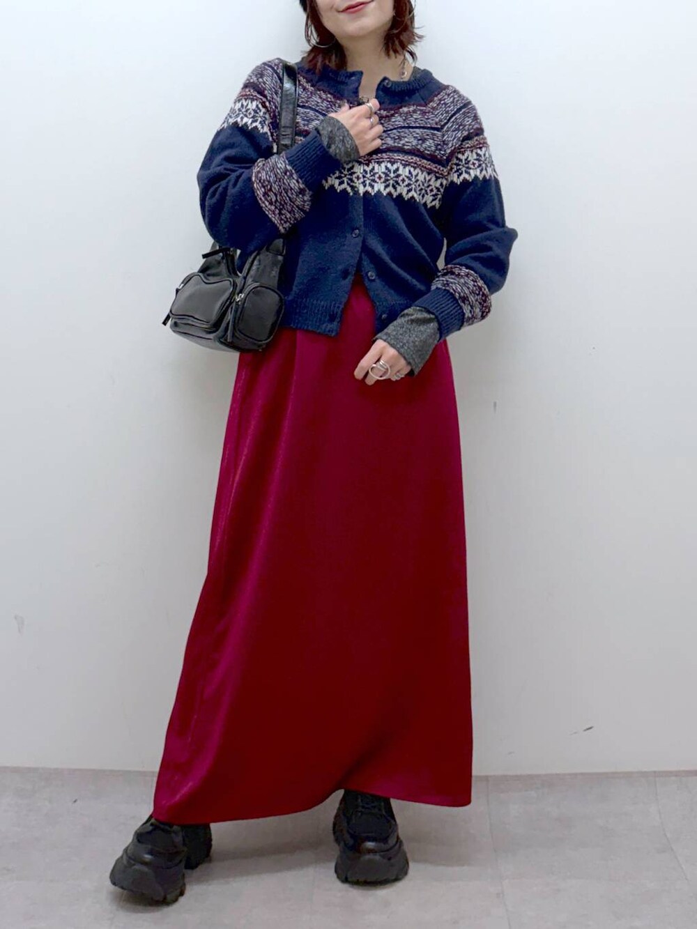 ブラック系のブーツ、シルバー系のTシャツ/カットソー、ブラック系のショルダーバッグを着用したレディースの冬コーディネートの3枚目の写真