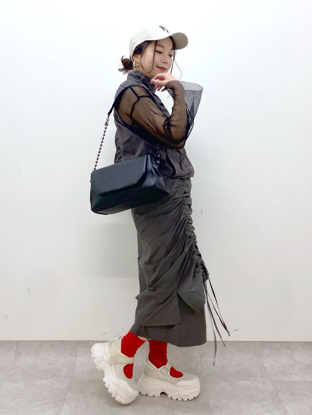 グレー系のスカート、ブラック系のショルダーバッグ、ブラック系のTシャツ/カットソーを着用したレディースの春コーディネートの5枚目の写真