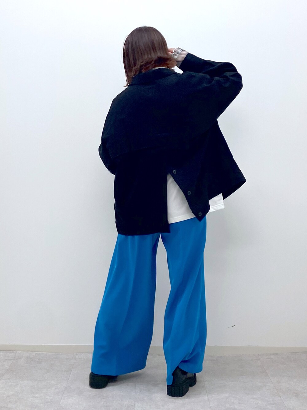 ホワイト系のTシャツ/カットソー、グリーン系のシャツ/ブラウス、ブルー系のスラックスを着用したレディースの春コーディネートの4枚目の写真